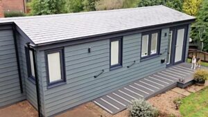Aerial view of a blue-grey granny annexe with tiled roof and ramped decking