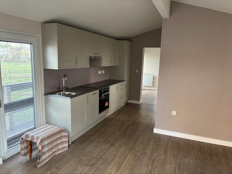A stone coloured galley kitchen in a garden annexe