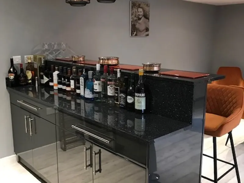 Bespoke garden bar interior with fitted cabinets, drinks counter and pendant lighting