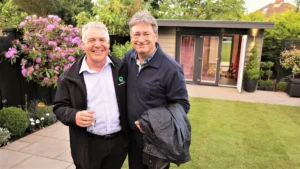 Alan Titchmarsh and Brian standing in front of the completed garden room