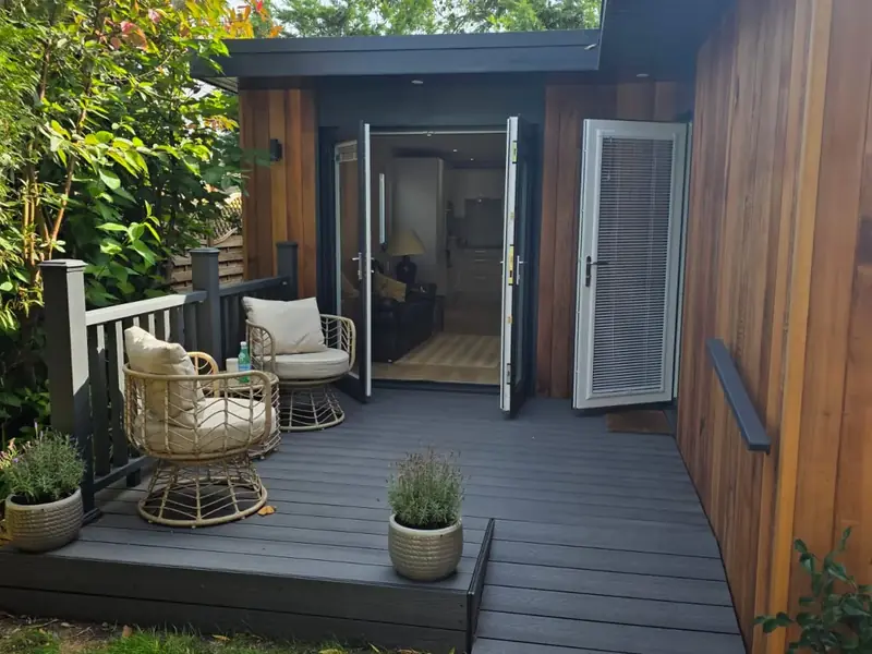 Covered composite decking and entrance to a bespoke one-bedroom garden annexe.